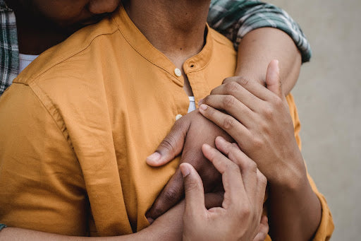 Two men embracing and holding hands