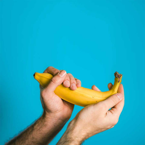 man's hands holding a banana