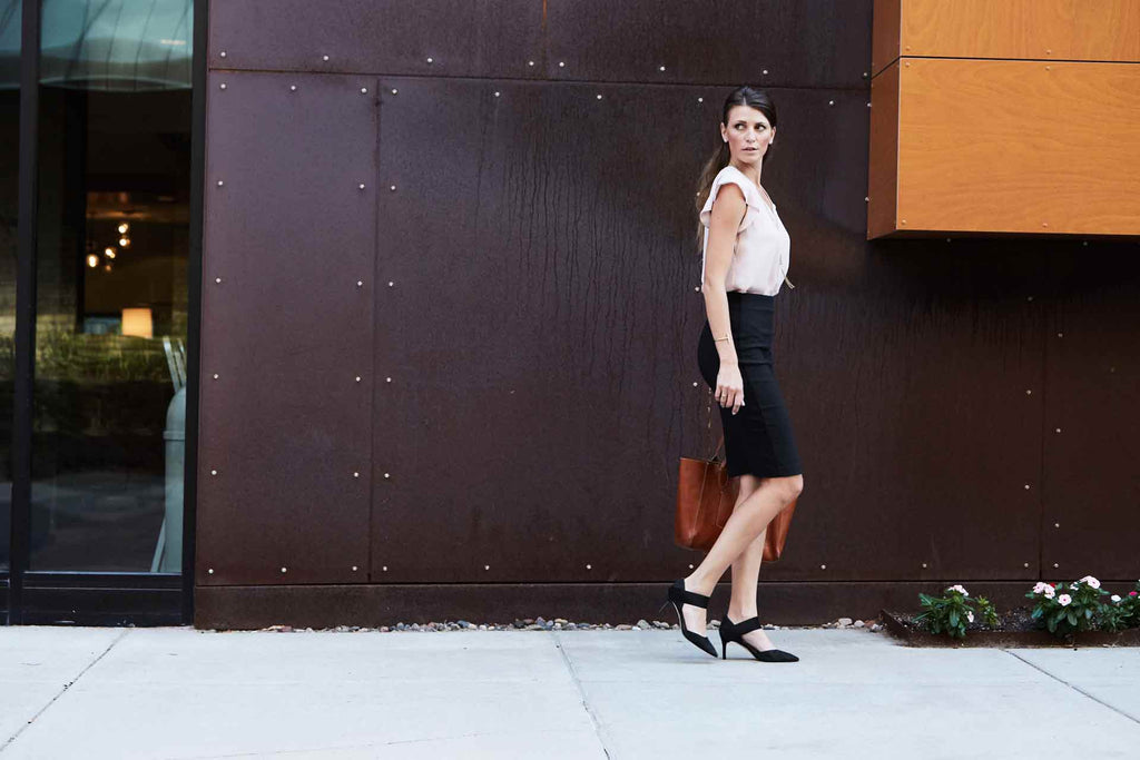 confident woman in pencil skirt and removable black high heel strap walking on city street