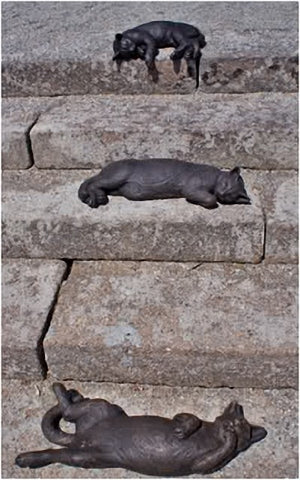 Sculptures of cats laying on stone steps