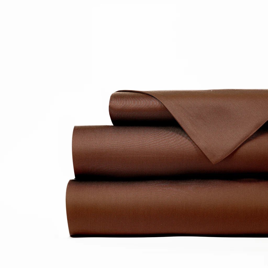Stack of folded brown bed sheets on a white background.