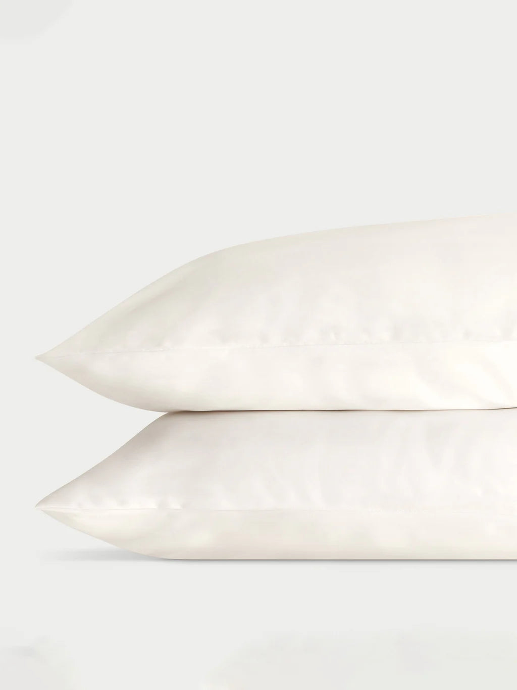 Two stacked white pillows against a light gray background.