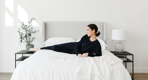 Woman in Cozy Earth loungewear laying on bed