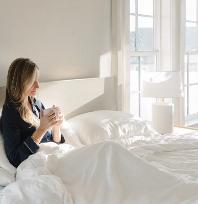 Woman sitting in bed with coffee mug