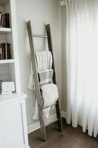 Blankets folded neatly on the rungs of a ladder