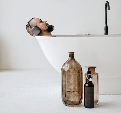 Man with headphones enjoying a bath