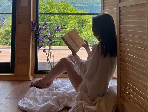 Woman reading on the floor by the window