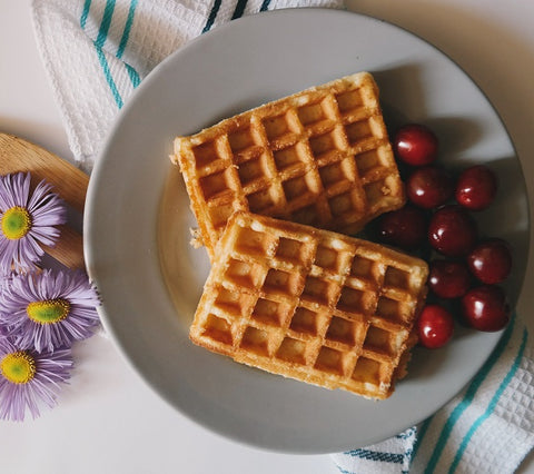 Plate of waffles with dish towel and flowers