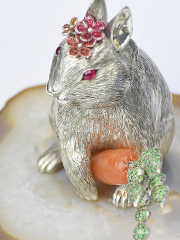 Looking at silver rabbit sculpture from above with a focus on the carved carnelian carrot