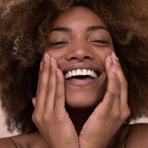 Woman smiling touching face