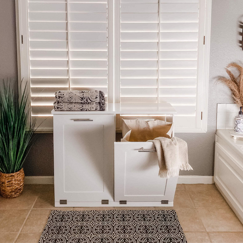 White, double, tilt-out laundry hamper in a minimalist bathroom.