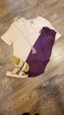 Casual summer ensemble: beige top, plum skirt, and tumbler
