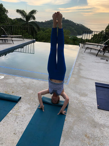 Woman doing yoga in front of pool