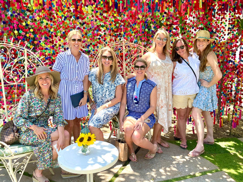 Women in dresses in front of a colorful dot background