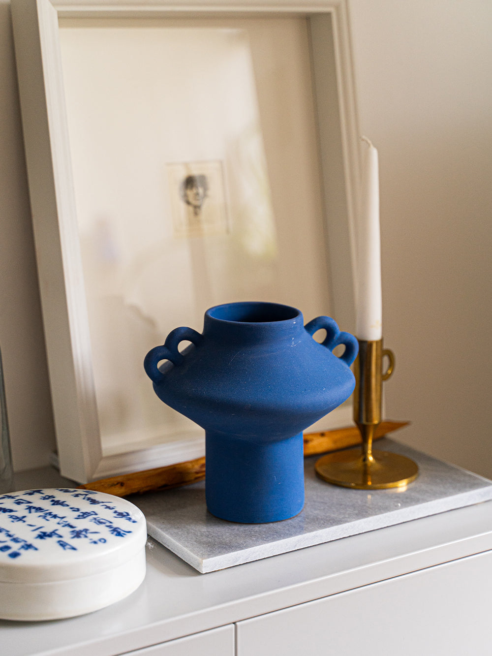 Blue vase with candle holder and framed artwork as show pieces