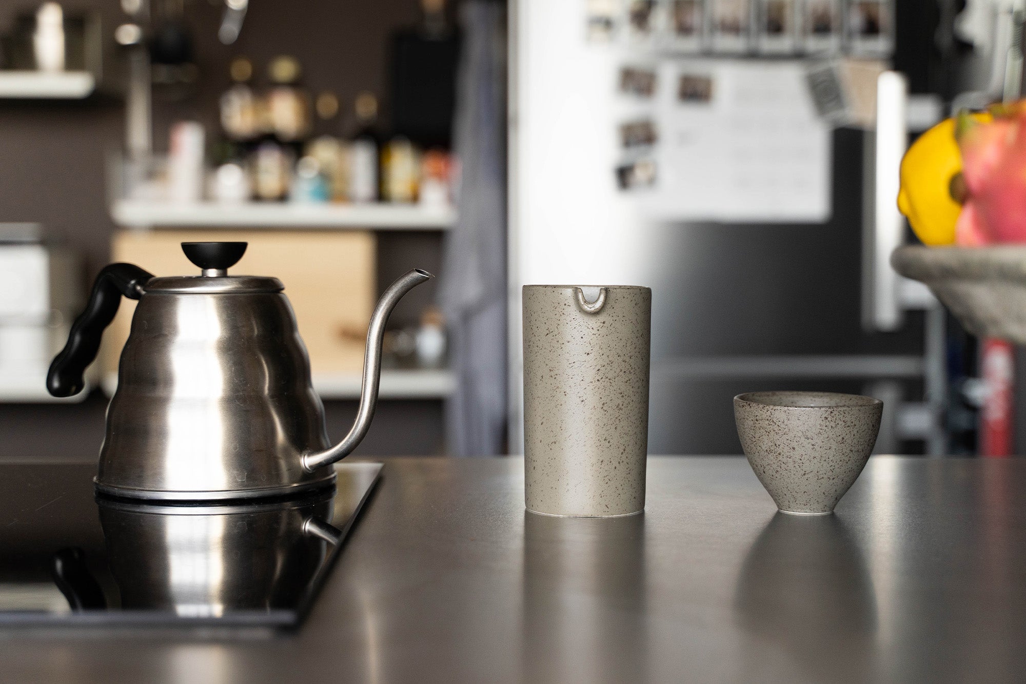 Kitchen tabletop featuring a goose neck kettle and cups