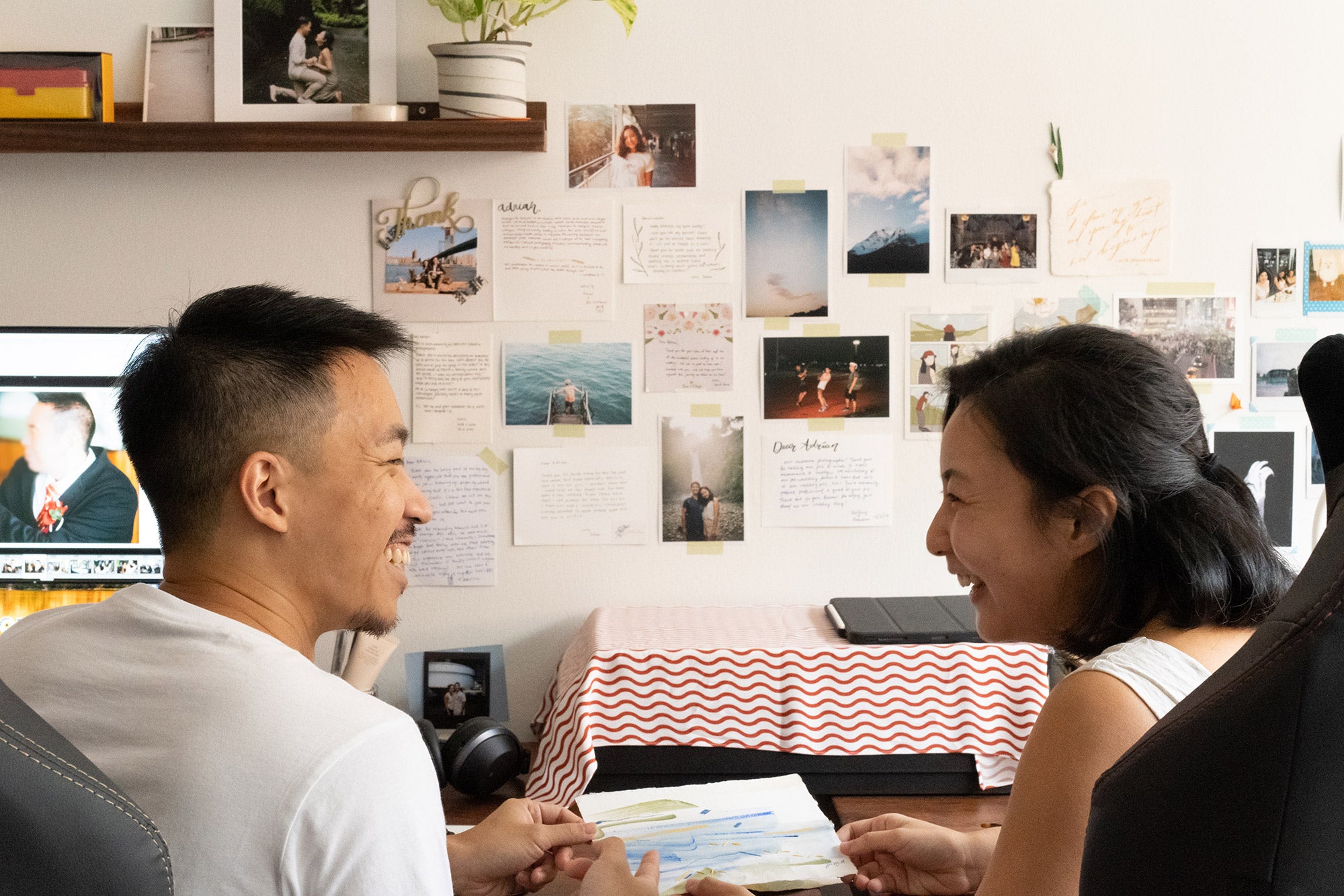 Singaporean couple laughing while working from home together