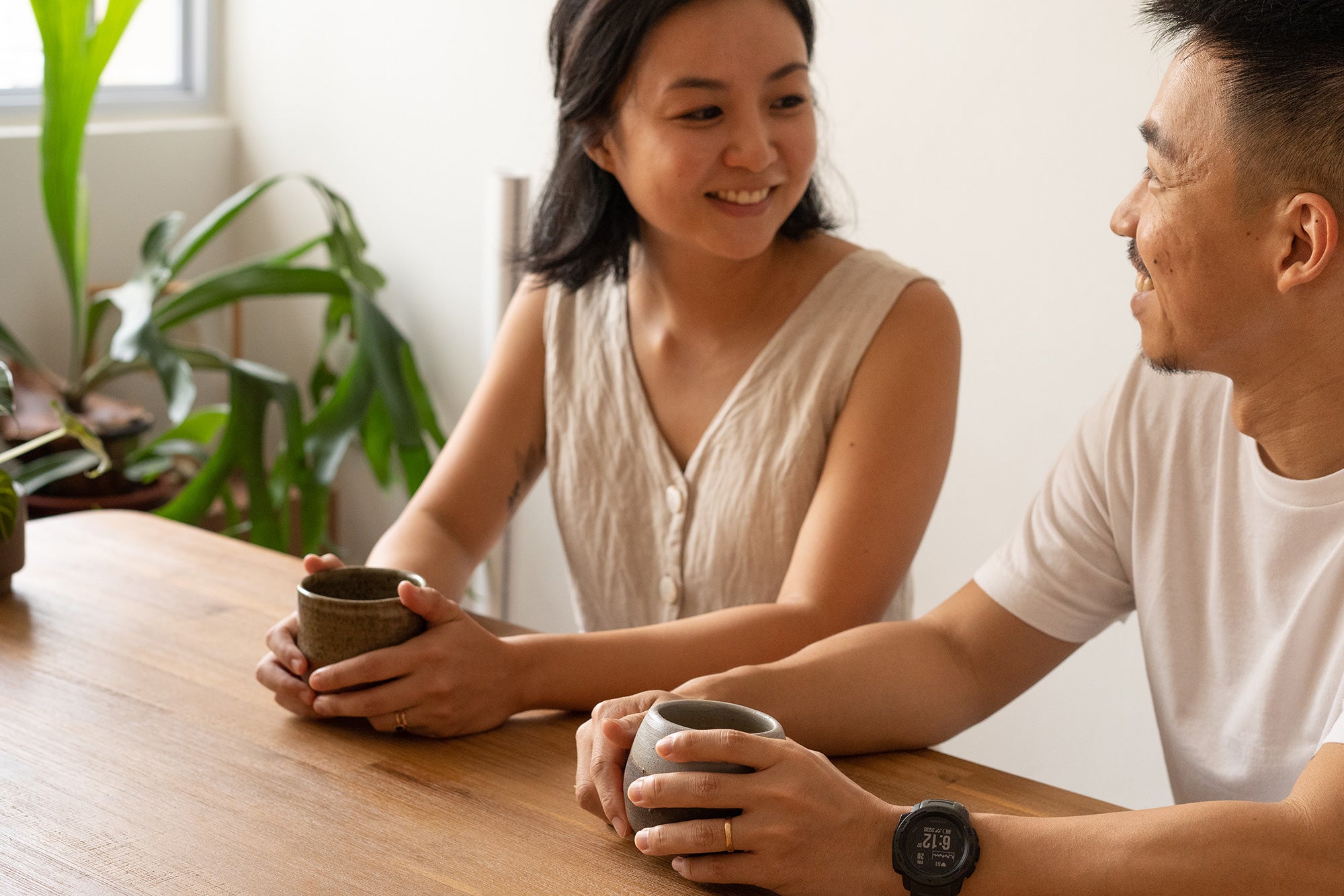 Asian couple having morning coffee in dining area