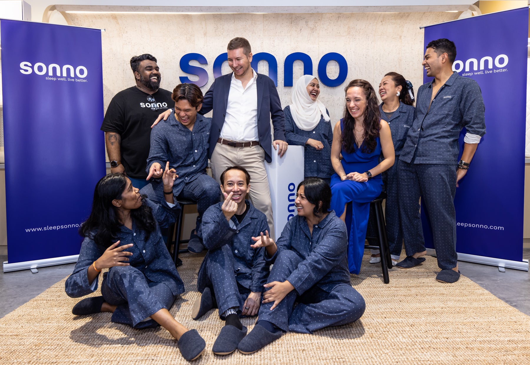 A group of Sonno team members dressed in pyjamas, smiling at the camera