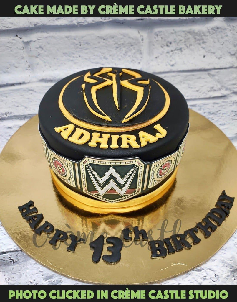 A Cake For A Wwe Fan In Black Fondant With Logo At The Top And Championship Belt On The Sides Creme Castle