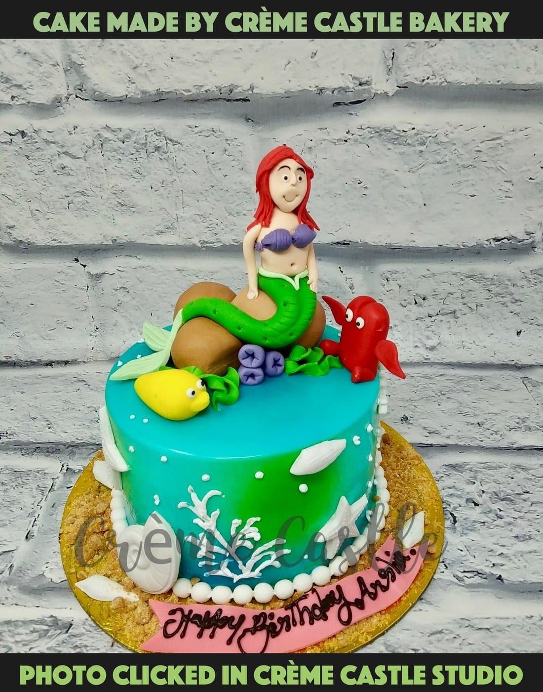 A mermaid theme cake with mermaid on top of a cake looking like ...