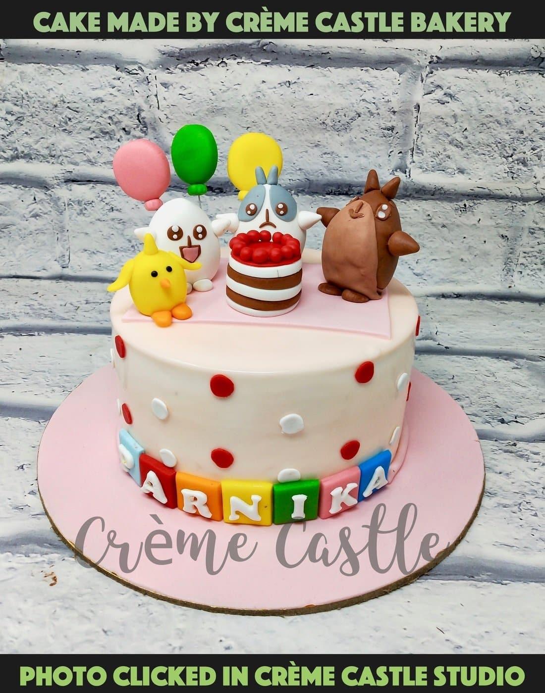 A cake with famous cartoon characters on top in pink base and ...