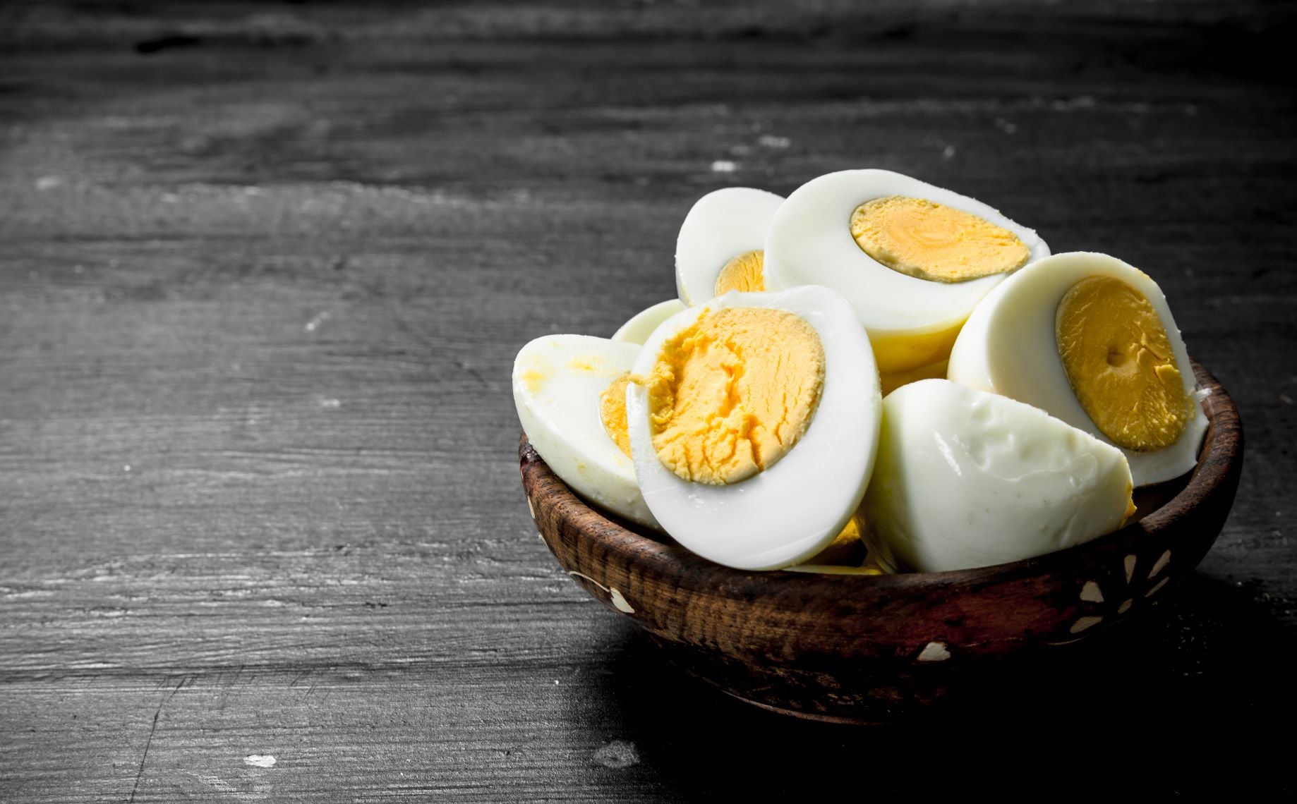 A wooden bowl with sliced boiled eggs for babies. Eggs are a great healthy food option for babies.