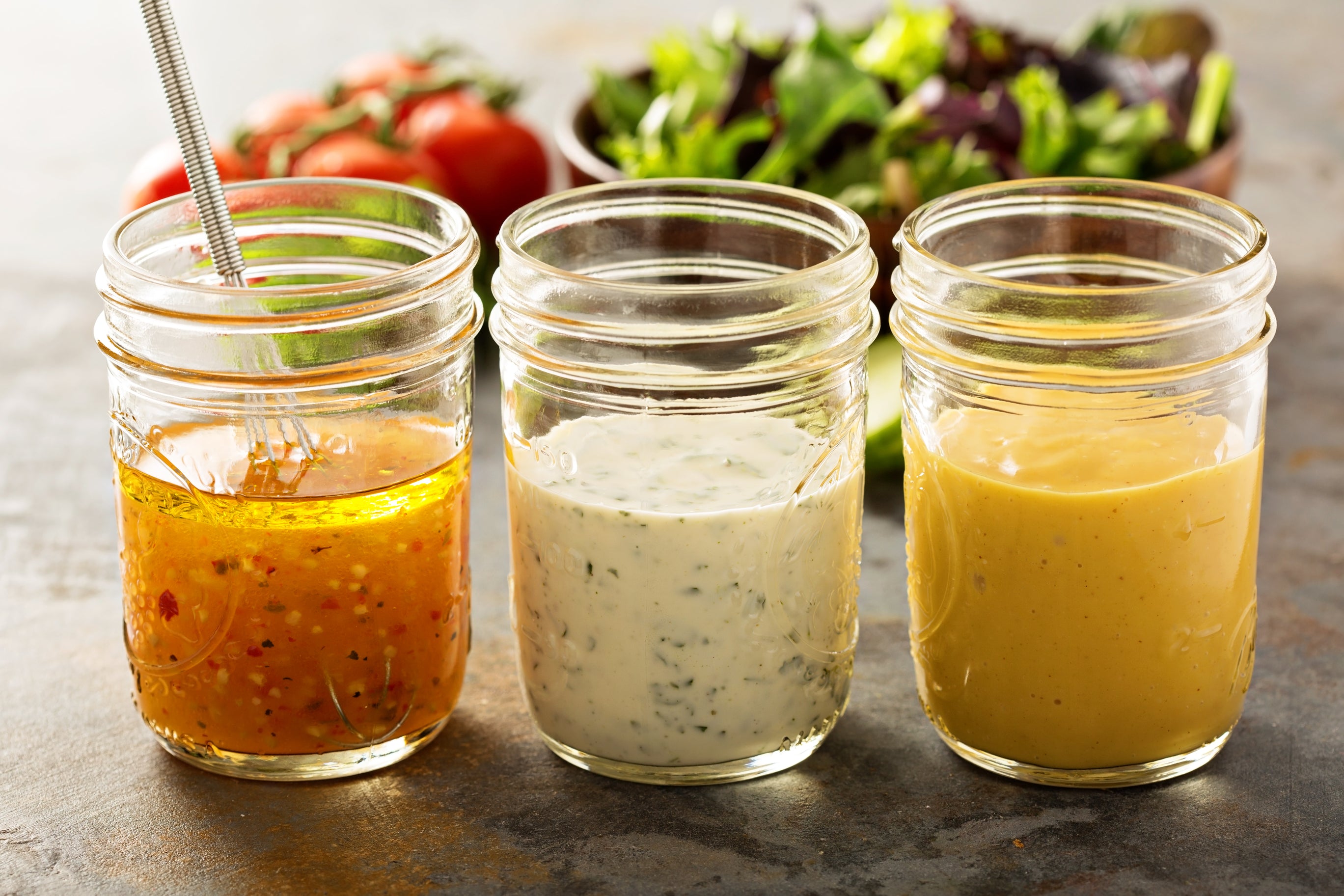 Different types of salad dressing stored in old baby food jars. Baby food jars can be upcycled and be used to store a number of items.