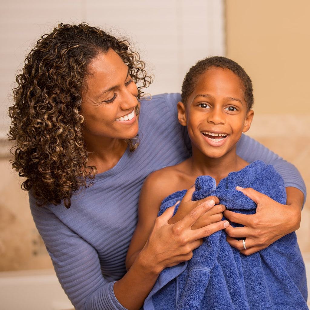 Mother drying off son with blue towel