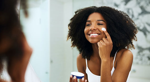 Female applying moisturiser to face