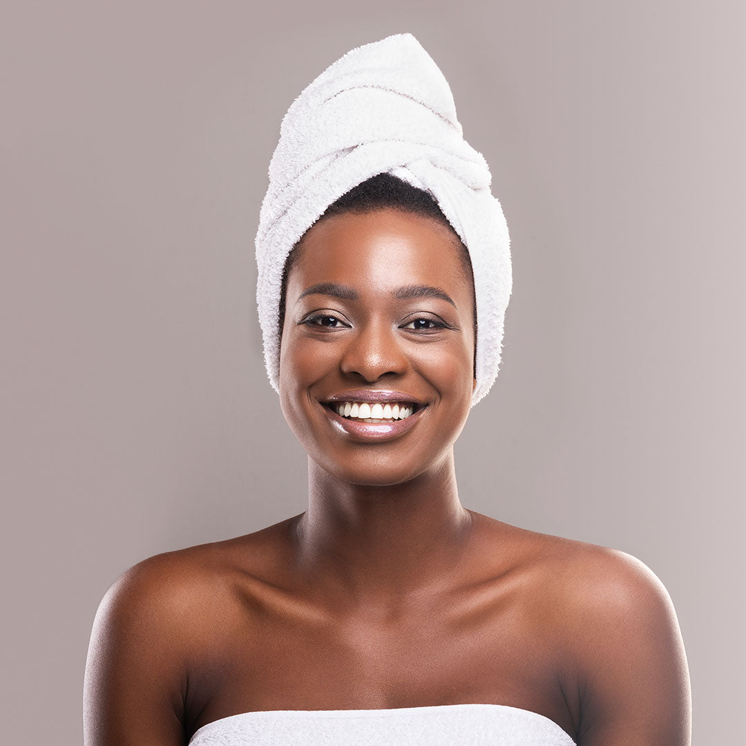 young african woman wrapped in white bath towel