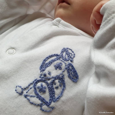 Hand embroidered hare on baby sleep suit