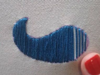 Blue embroidered satin stitch on a plan fabric background