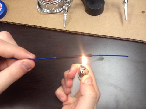 Photo of arm's of a man holding lighter and wire