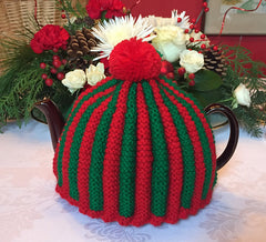 a red and green tea cosy on a Christmas themed table
