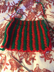 the back of a red and green knitted tea cost in progress