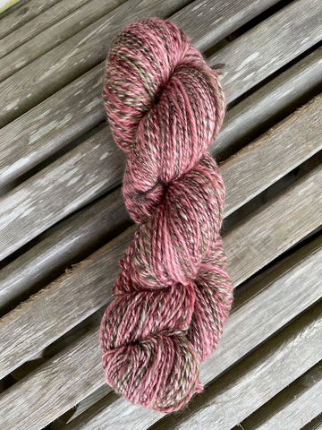Pink variegated handspun skein. It has some greens in it. 