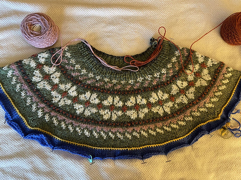 Color work sweater with white flowers around the yoke on a green background