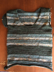 dark green and light teal striped tee with one sleeve barely started