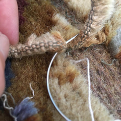Close-up showing warp threads being sewn down