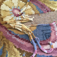 Rug with damage showing strips pulled off of the backing