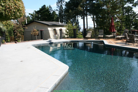 Glowing concrete pool deck Powered by AGT™ Commercial-Grade 1/2" Glow Stone in Sky Blue & Aqua Blue during the day.