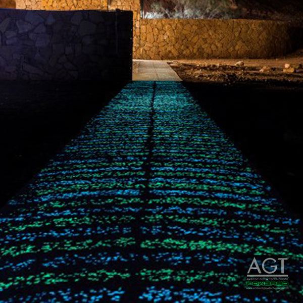 Close up view of a glowing concrete pathway at night using 1/2" (12-14mm) AGT™ Emerald Yellow and Aqua Blue Glow Stones.