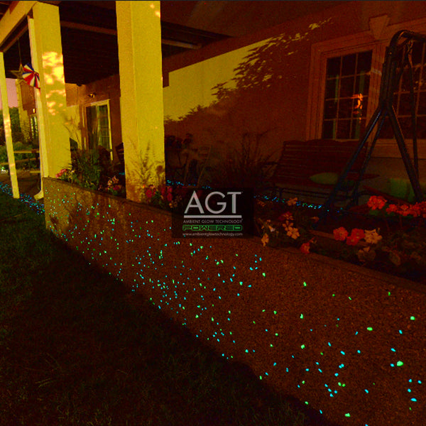 Glowing concrete decorative wall and outdoor kitchen island powered by AGT™ Commercial-Grade Glow Stone in Emerald Yellow and Aqua Blue 1/2" shown at night