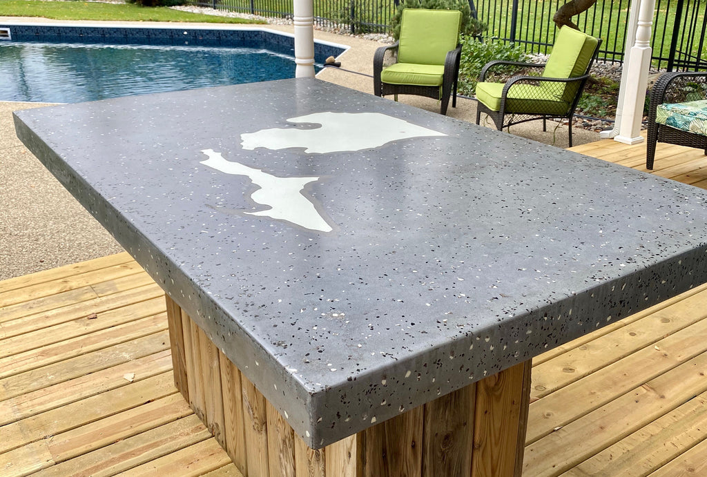 Backyard glowing concrete table with Michigan State silhouette in AGT™ Fine Glow Sand in the day time