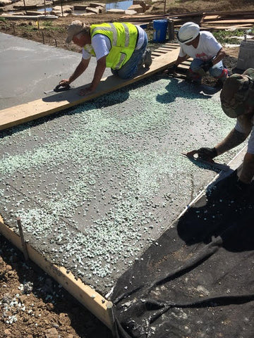 Installing the AGT ULTRA Grade 1/2" Glow Stone into the fresh concrete surface.