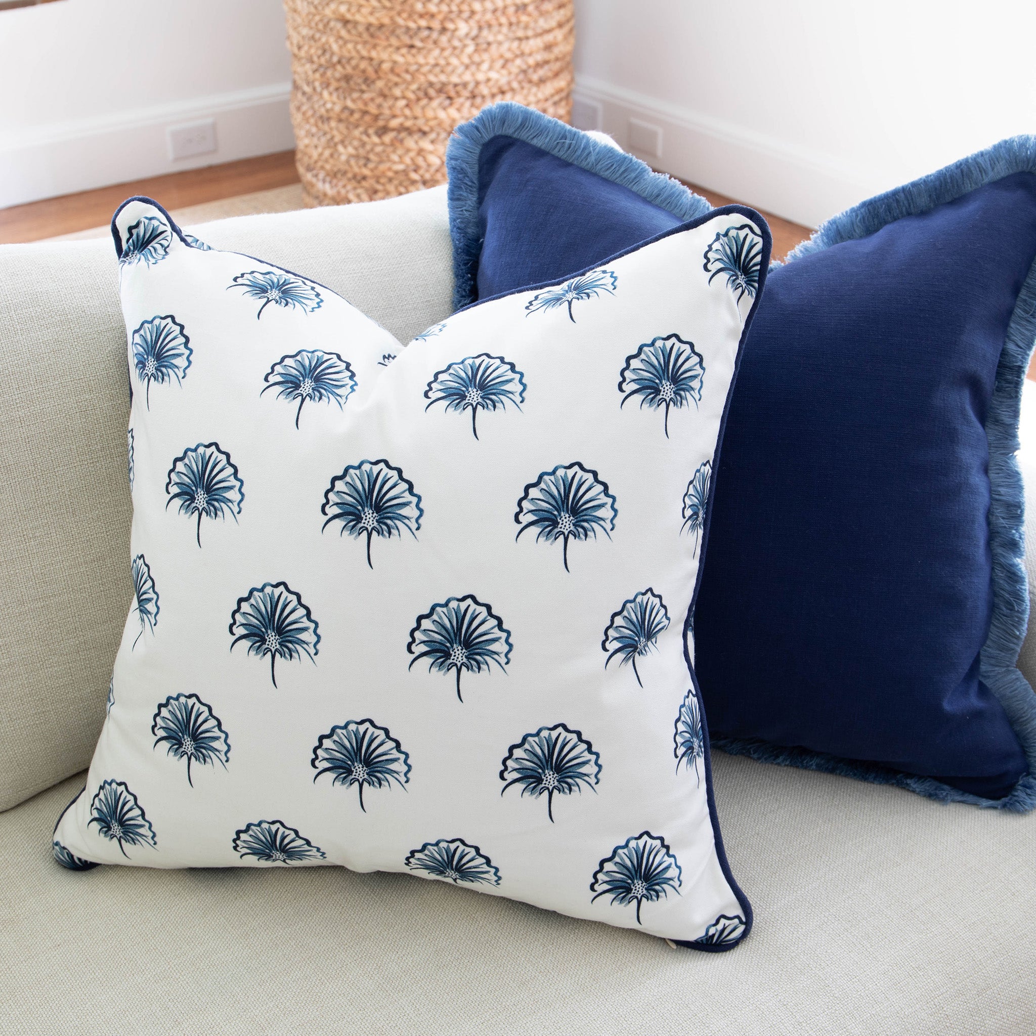 Floral navy custom pillow and navy blue custom pillow styled on a white couch