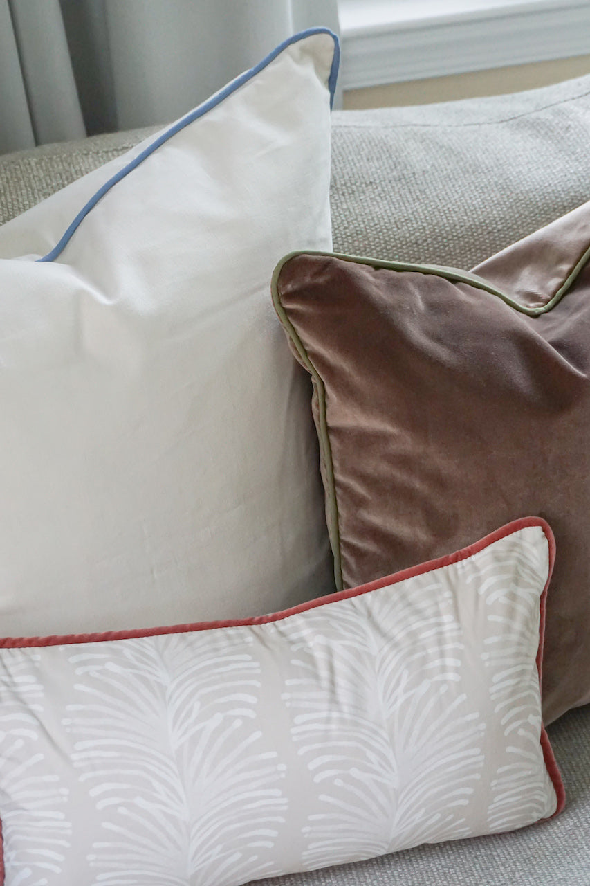 Close-up of Natural White Custom Pillow, Brown Velvet Custom Pillow, and Sand Colored Botanical Stripe Custom Lumbar Pillow