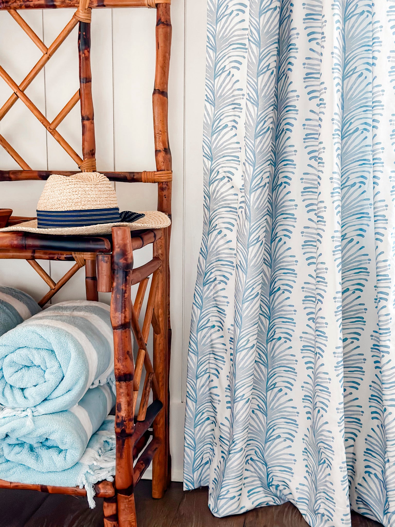 Close-up of Sky Blue Botanical Stripe custom curtain next to wooden hanger stand