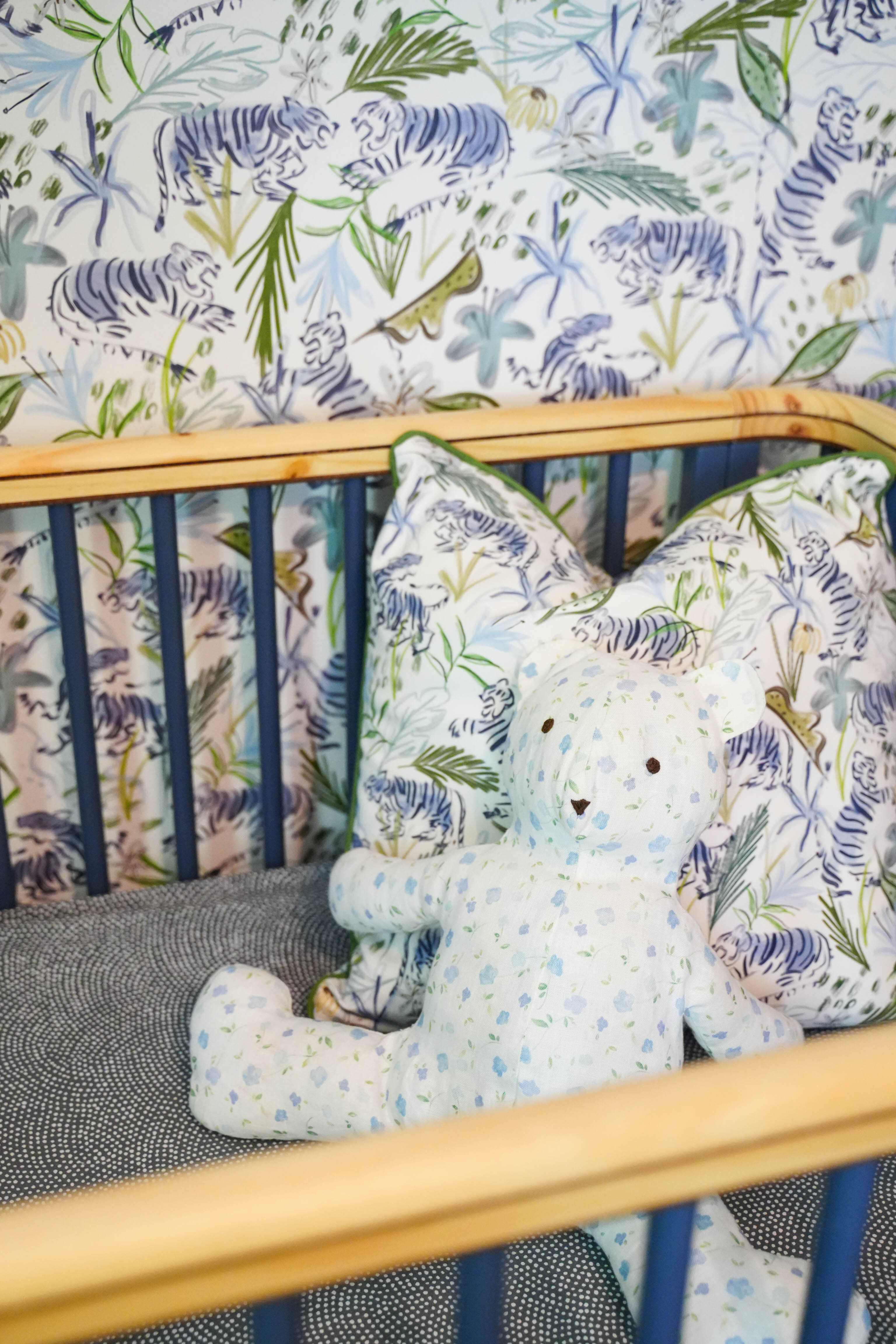Close-up of crib with a Green Tiger custom pillow in front of Green tiger custom wallpaper